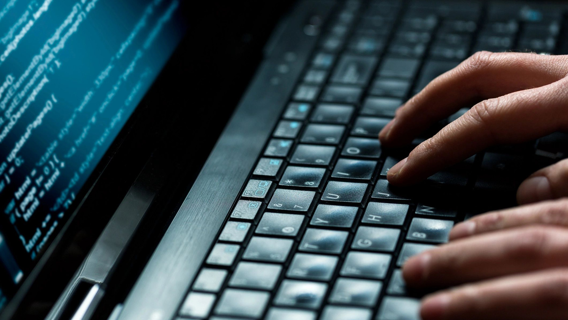 A person typing on a laptop keyboard.