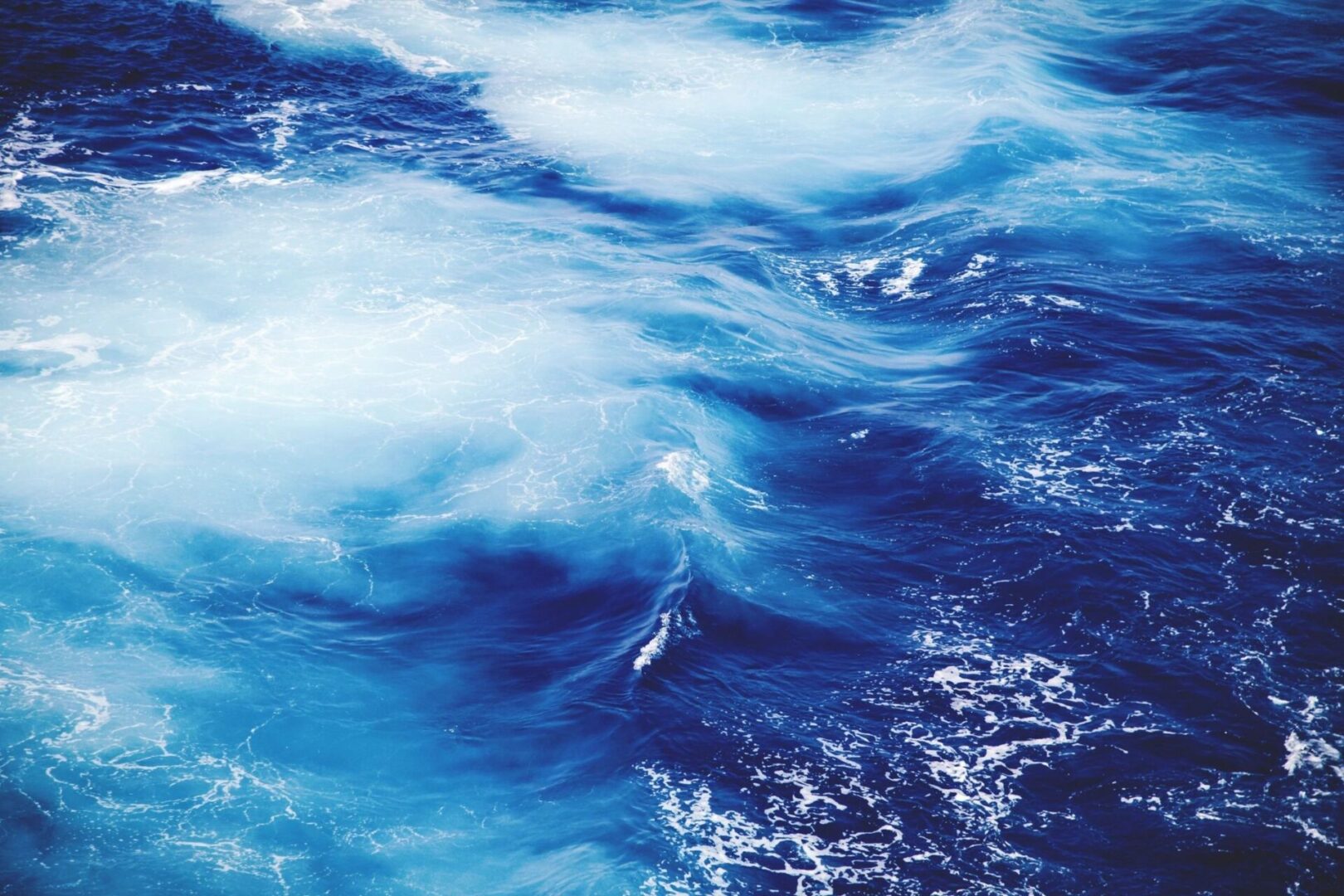 A body of water with blue and white waves.